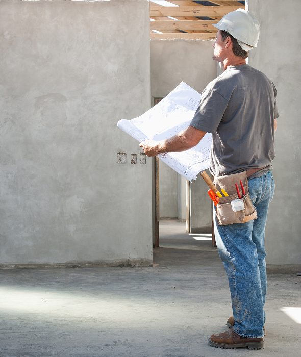 Builder studying architectural blueprints