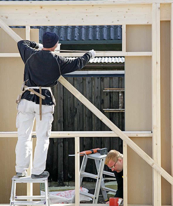 Builders assembling outdoor wooden structure